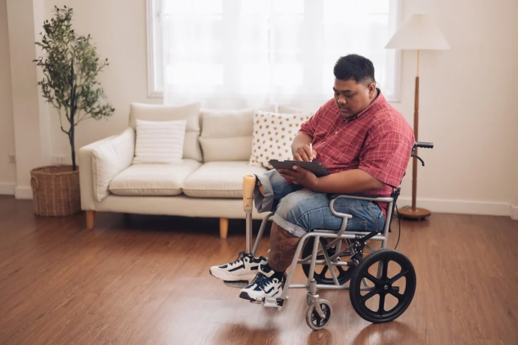 Disabled man in wheelchair using tablet